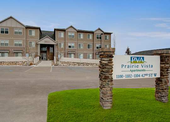 The image shows a building with a sign in front that reads "Prairie Vista Apartments".