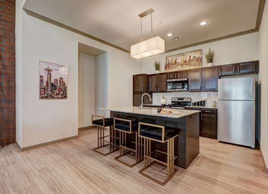 A kitchen with a bar stool and a fridge.