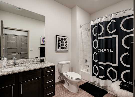 A bathroom with a sink, toilet, and a shower curtain.