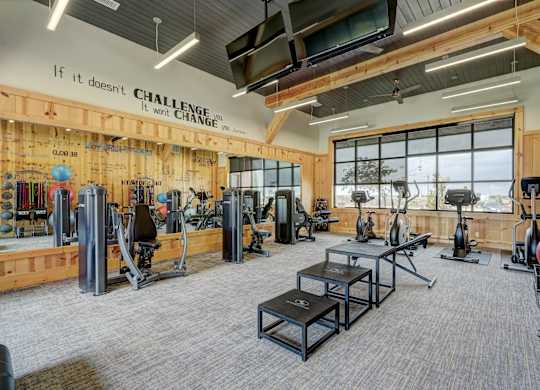 A gym with a sign that says "If it doesn't challenge you, it won't change you.".