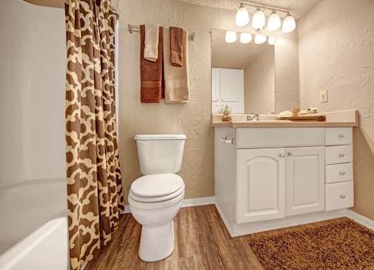 A bathroom with a toilet, sink, and shower curtain.