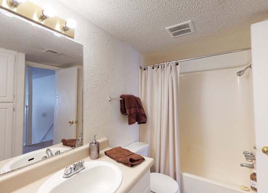 A white bathroom with a towel on the towel rack.