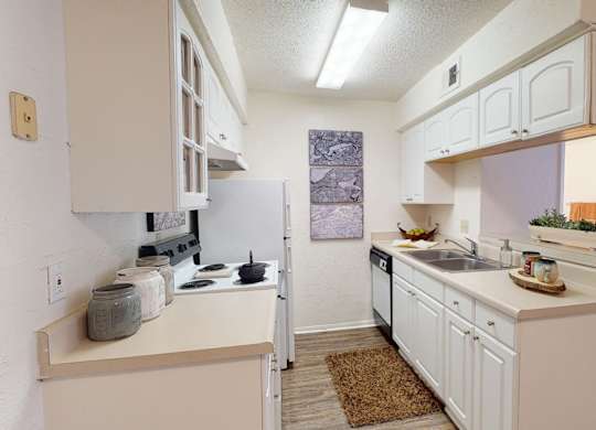 A kitchen with white cabinets and appliances.