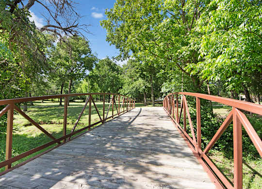 A bridge with a metal railing and a wooden walkway.