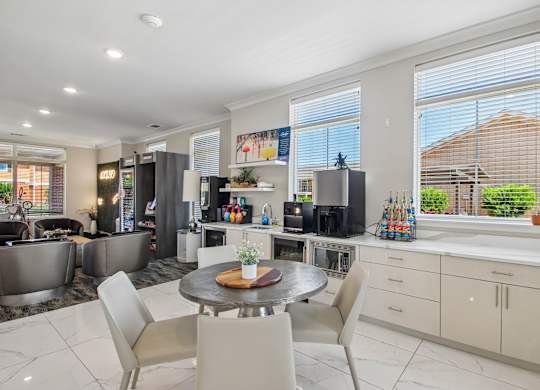 A modern kitchen with a dining table and chairs.
