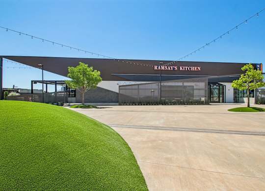 A building with a green lawn in front and a sign that says "Ramsay's Kitchen".