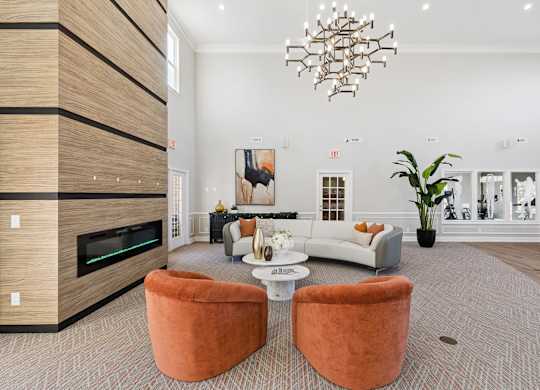 A modern living room with a fireplace and a large chandelier.