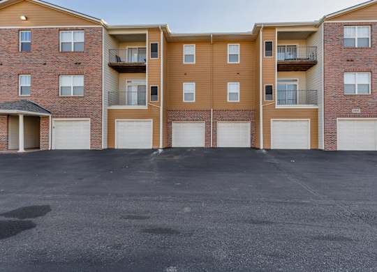 A parking lot in front of a brick apartment building.