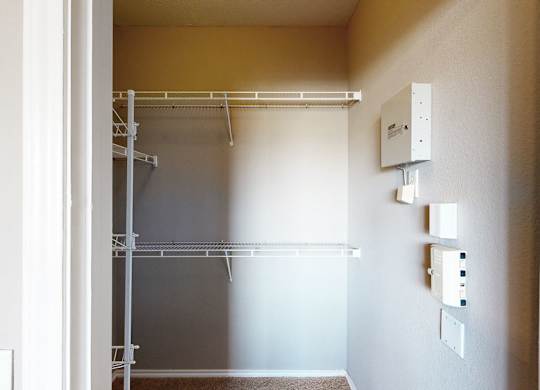 A white doorway opens to a room with a white wall and a white shelf.