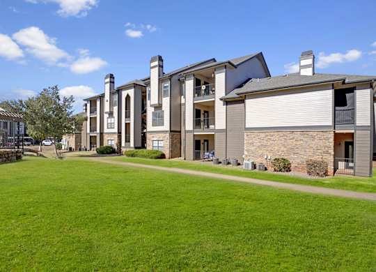 A row of modern houses with a green lawn in front.
