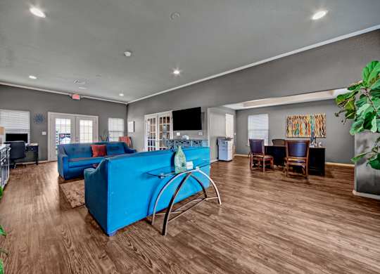 A living room with a blue sofa and wooden floors.