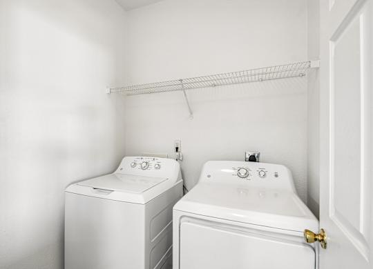 A white washing machine and sink in a small bathroom.