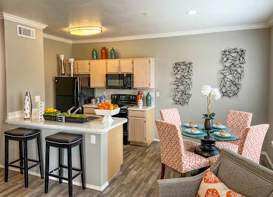 A kitchen with a bar area and a dining table with chairs.