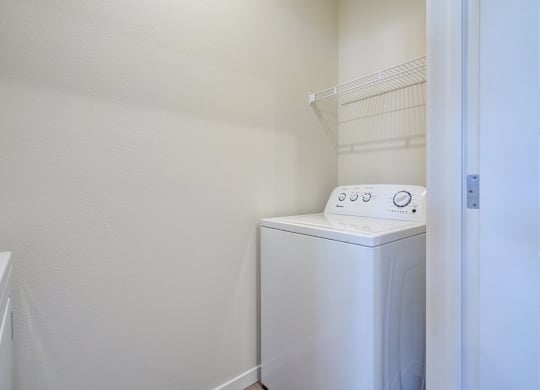 A white washing machine in a laundry room.