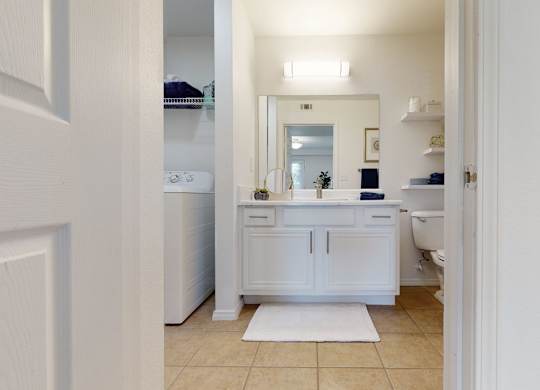 A white bathroom with a mirror and a sink.