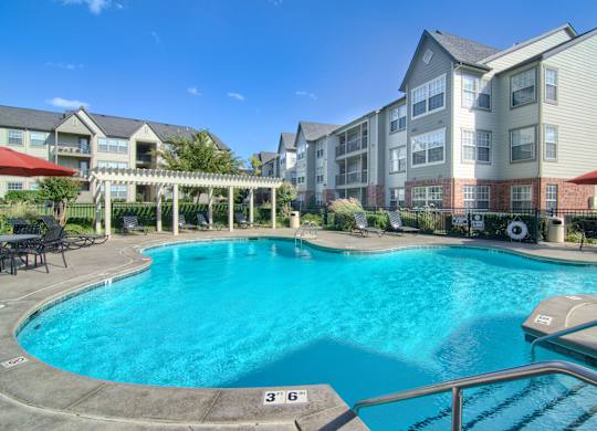 A large swimming pool in front of apartment buildings.