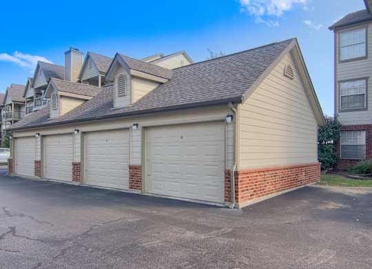 A house with a garage is situated in a driveway.