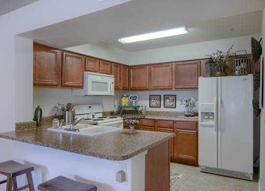 A kitchen with brown cabinets and a white fridge.