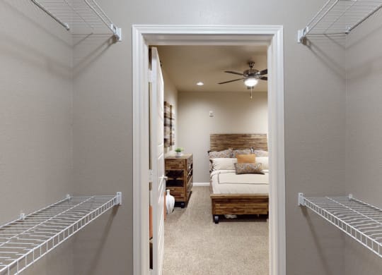 a bedroom with a ceiling fan and two walk in closets