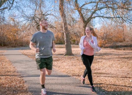 A man and a woman running down a road at Legends of River Oaks