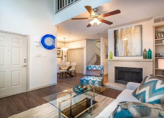 a living room with a ceiling fan and a fireplace