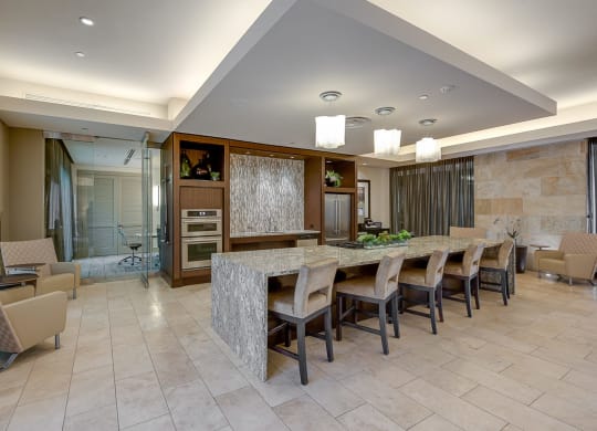 a large kitchen with a long counter and chairs