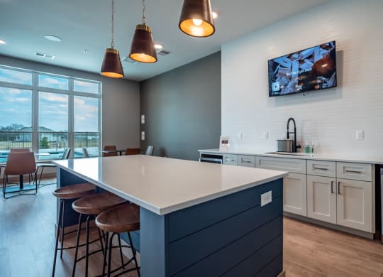 a kitchen with a large counter and a tv on the wall