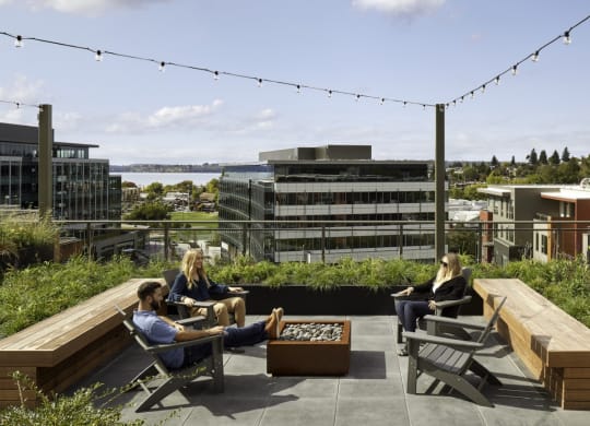 a group of people sitting in chairs on a roof terrace