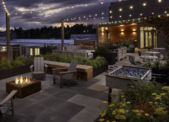 a rooftop terrace with a fire pit at night