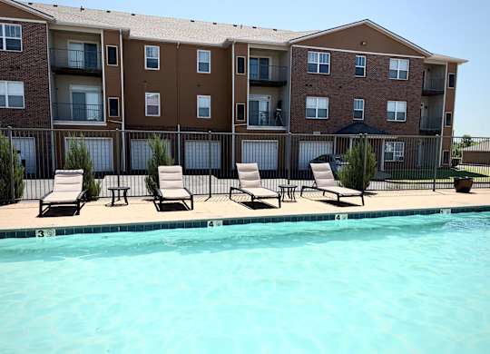 A large apartment complex with a pool in front.