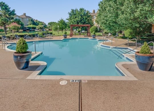 a swimming pool with trees and a gazebo in the background