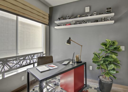 a home office with a desk and a plant