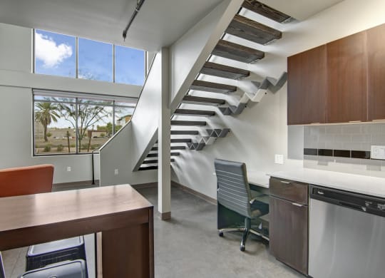 a kitchen with a table and chairs next to a staircase