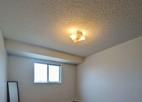 the living room of an empty house with wood flooring and a window