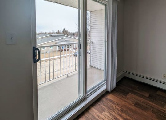 an empty living room with sliding glass doors to a balcony