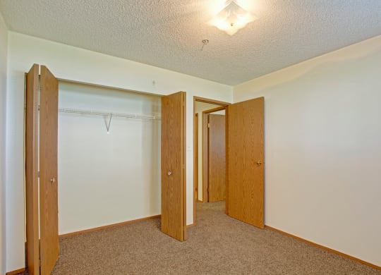 a empty room with a closet and a door to a bathroom