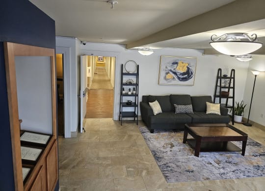 a living room with a couch and a table and a hallway with a staircase