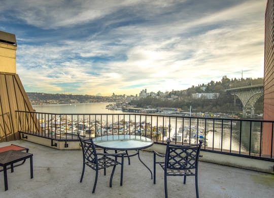a balcony with a view of a river and chairs and tables