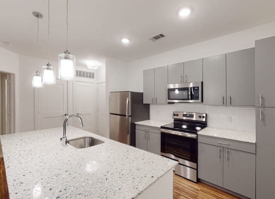 a kitchen with an island and stainless steel appliances