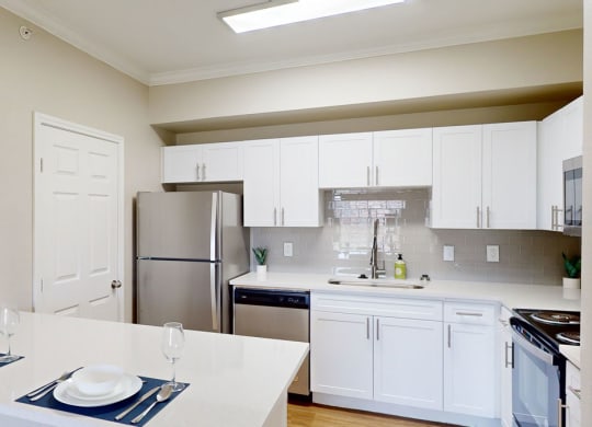 a kitchen with white cabinets and a stainless steel refrigerator