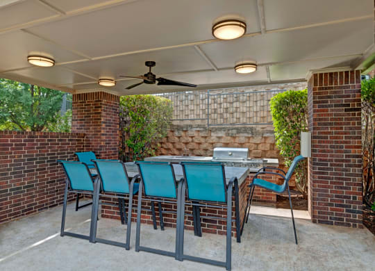 a patio with a table and chairs and a ceiling fan