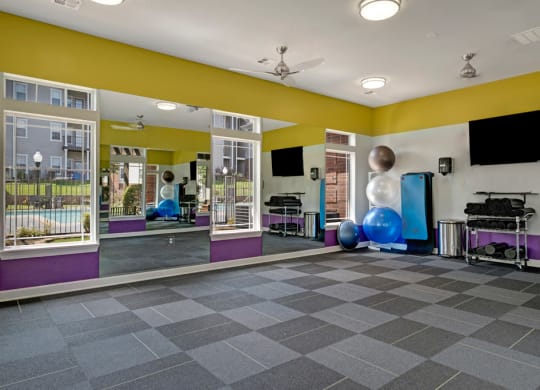 a fitness room with yellow walls and purple and yellow accents