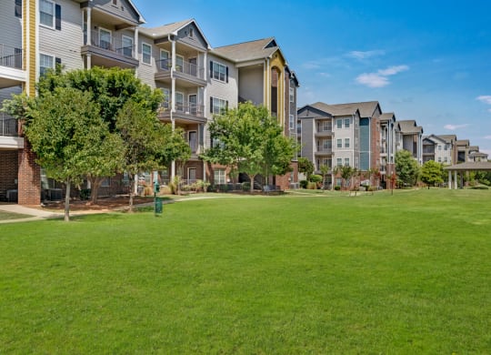 an apartment complex with a large green lawn