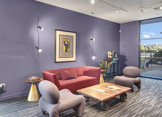 a living room with purple walls and a red couch