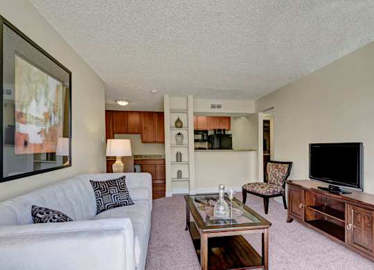 A living room with a white couch and a wooden coffee table.
