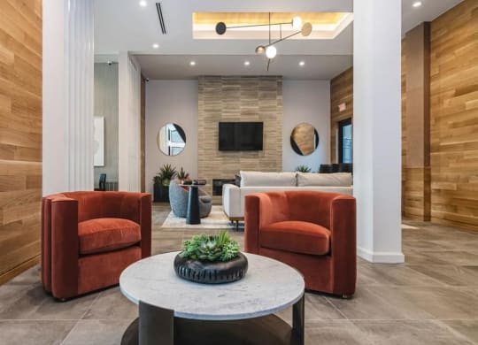 a living room with two orange chairs and a table