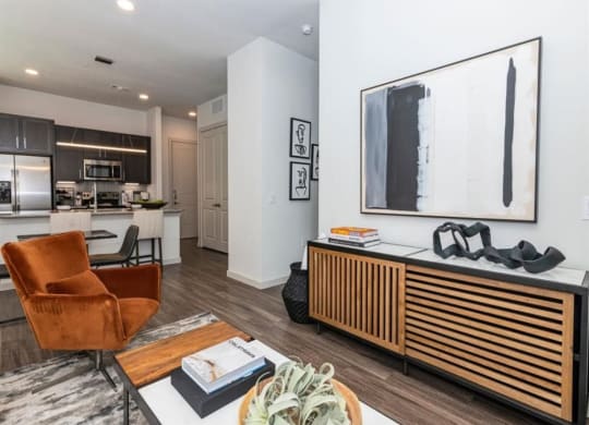 a living room with a table and chairs and a kitchen in the background