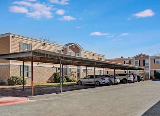 A convenient covered parking area here at Golden Crest with shaded carport spaces, paved drive lanes, and easy access to the surrounding apartment buildings, offering practical and protected parking for residents.