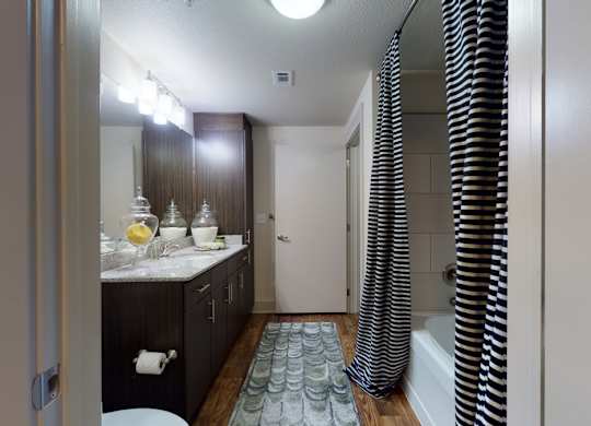 A bathroom with a sink, mirror, and shower.