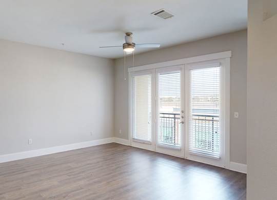 A room with a sliding glass door and a ceiling fan.